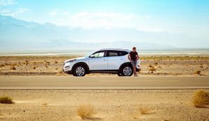 Man next to a car broken down.