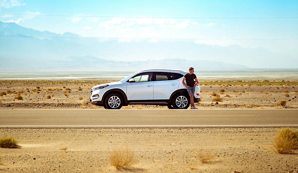Man next to a car broken down.